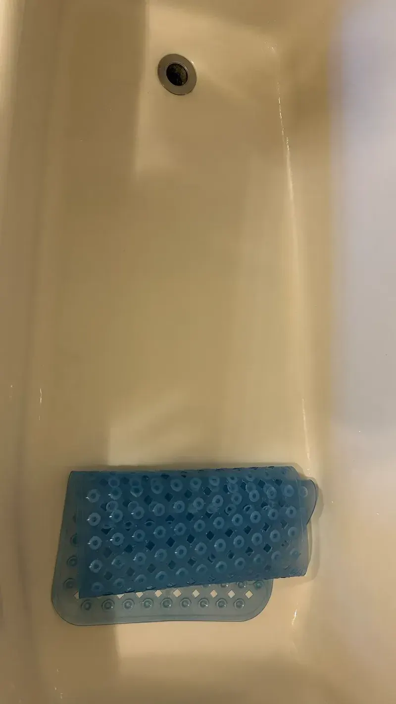 After: the bathtub with a bath mat, clean