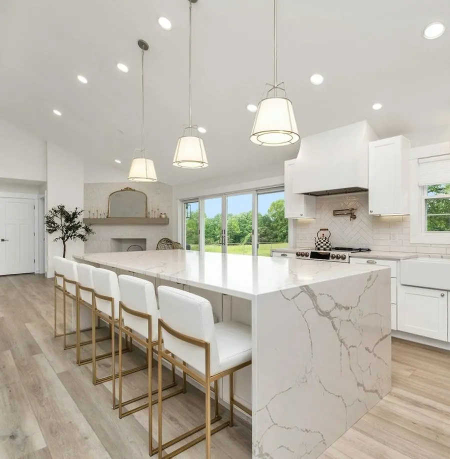 Bright white kitchen with a long marble island